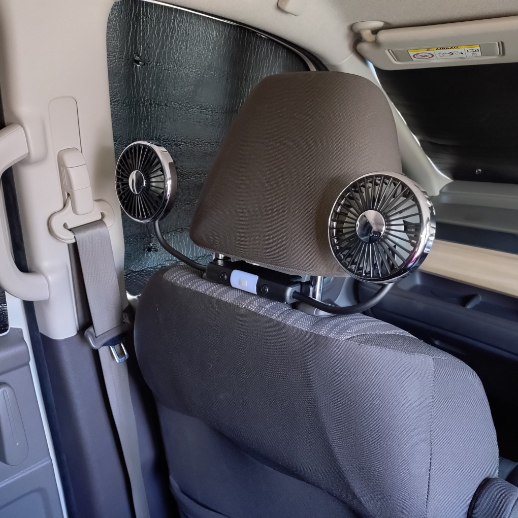フリード助手席ヘッドレストに装着した車載扇風機を両方後席に向けて送風している様子。後席に座る子ども2人に均等に風を送れる。