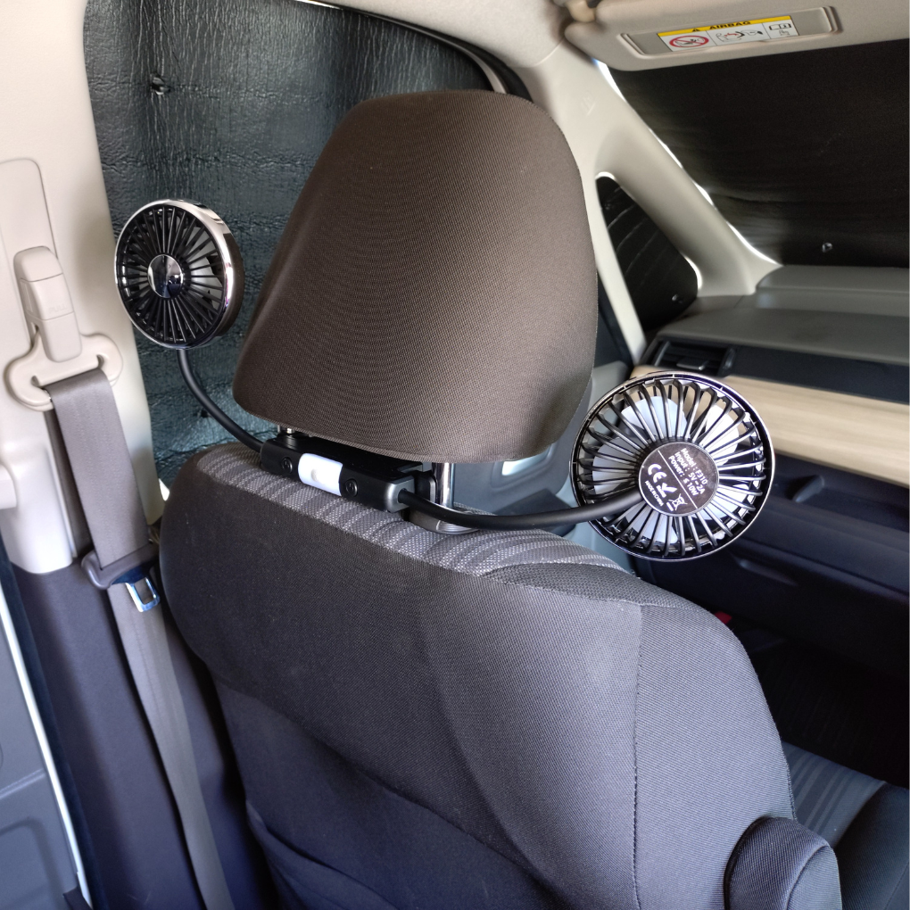 フリード助手席ヘッドレストに装着した車載扇風機を、片方を助手席・もう片方を後席に向けて送風している様子。助手席と後席で同時に使える柔軟スタイル。